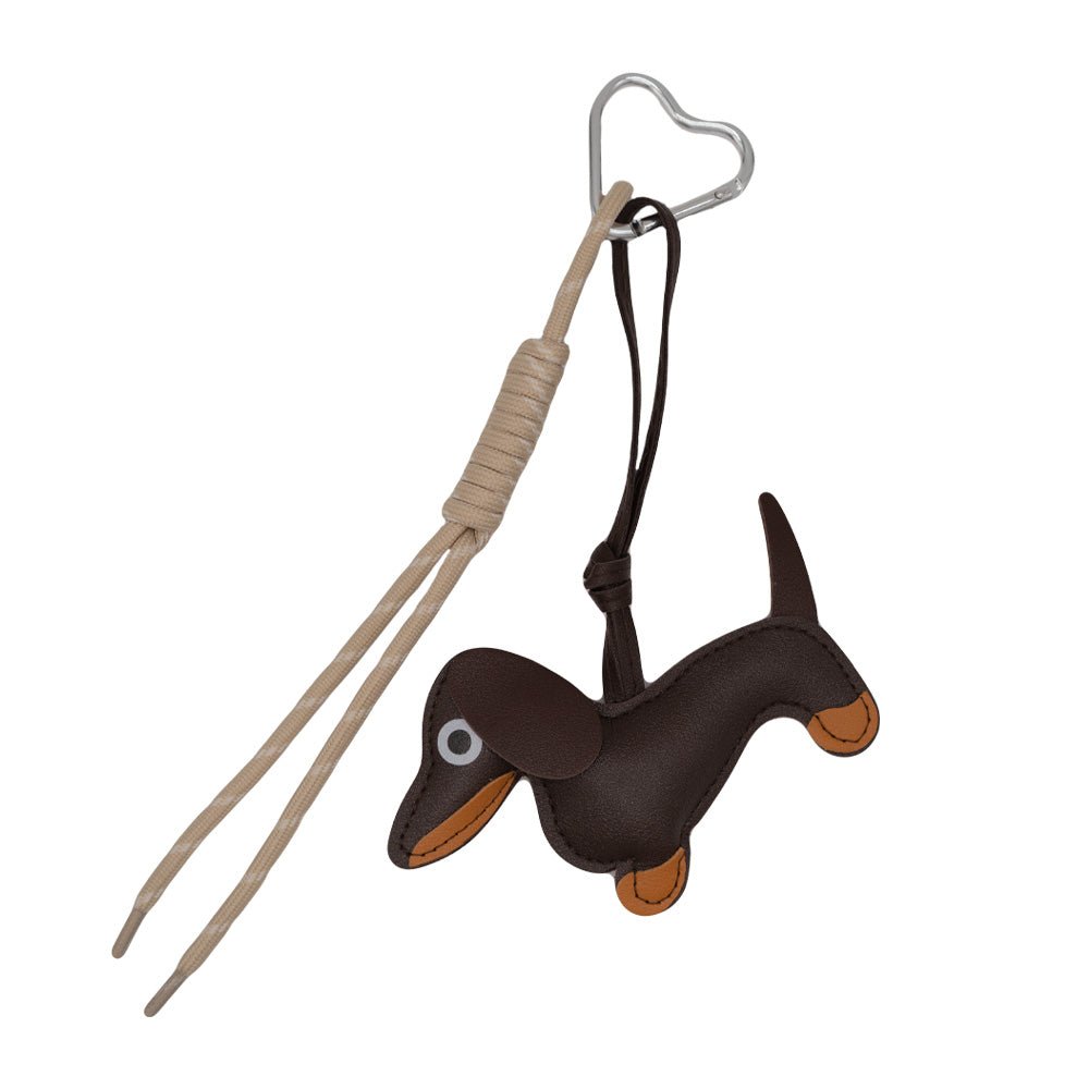 Charm with design that includes a brown Teckel with beige knotted rope. Includes silver heart-shaped carabiner.
