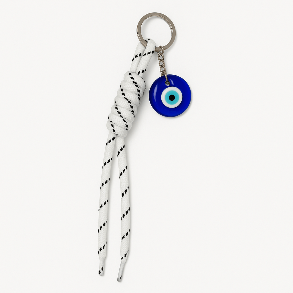 Charm with design that includes a crystal Turkish eye with a black and white knotted cord.
