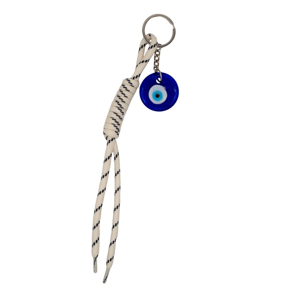 Charm con diseño que incluye un ojo turco de cristal con un cordón de nudo de color blanco y negro.
