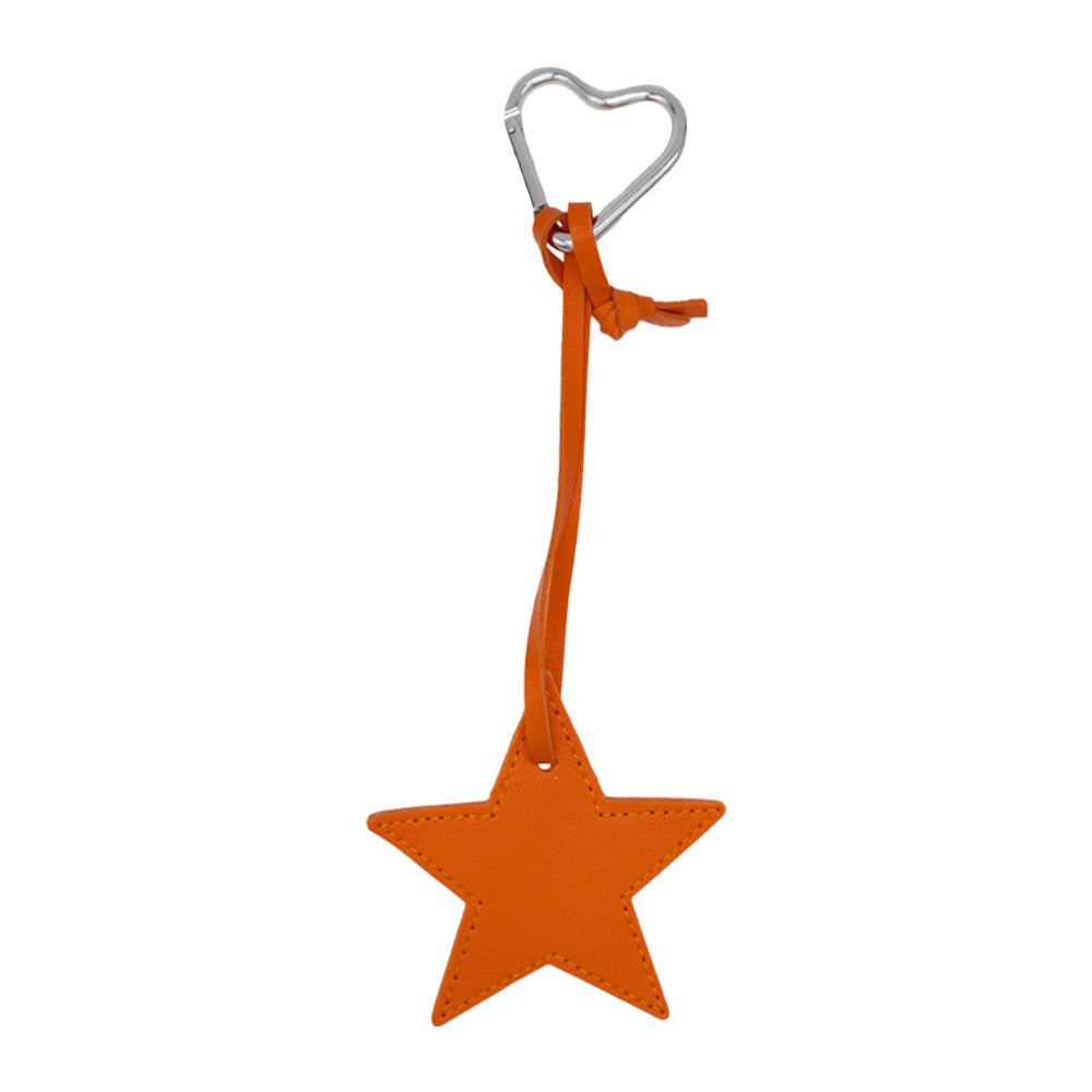 Charm con diseño que incluye una estrella de color naranja. Incluye mosquetón con forma de corazón plateado.
