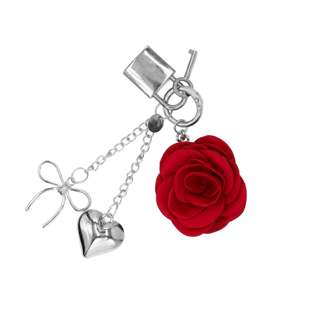 Charm with a design that includes a red rose and other silver elements, a padlock, a key, a heart and a bow.

