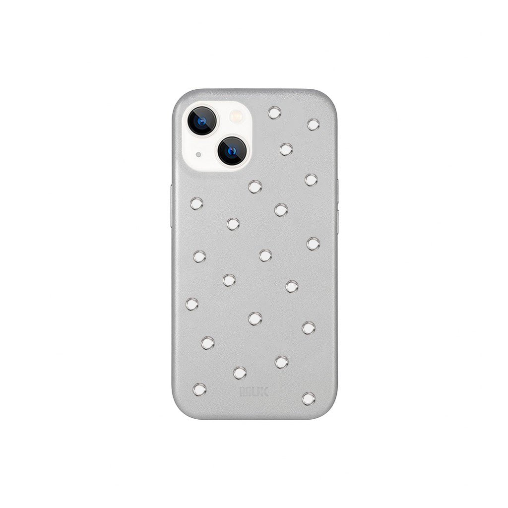 Funda de móvil en piel vegana plateada con diseño perforado y acabado antideslizante. 
Consejo para prevenir: Evita que la funda esté en contacto prolongado con ropa que destiñe (especialmente vaqueros). Y si la llevas dentro de un bolso o mochila, asegúrate de que el interior no suelte tinte, para mantenerla siempre impecable.
