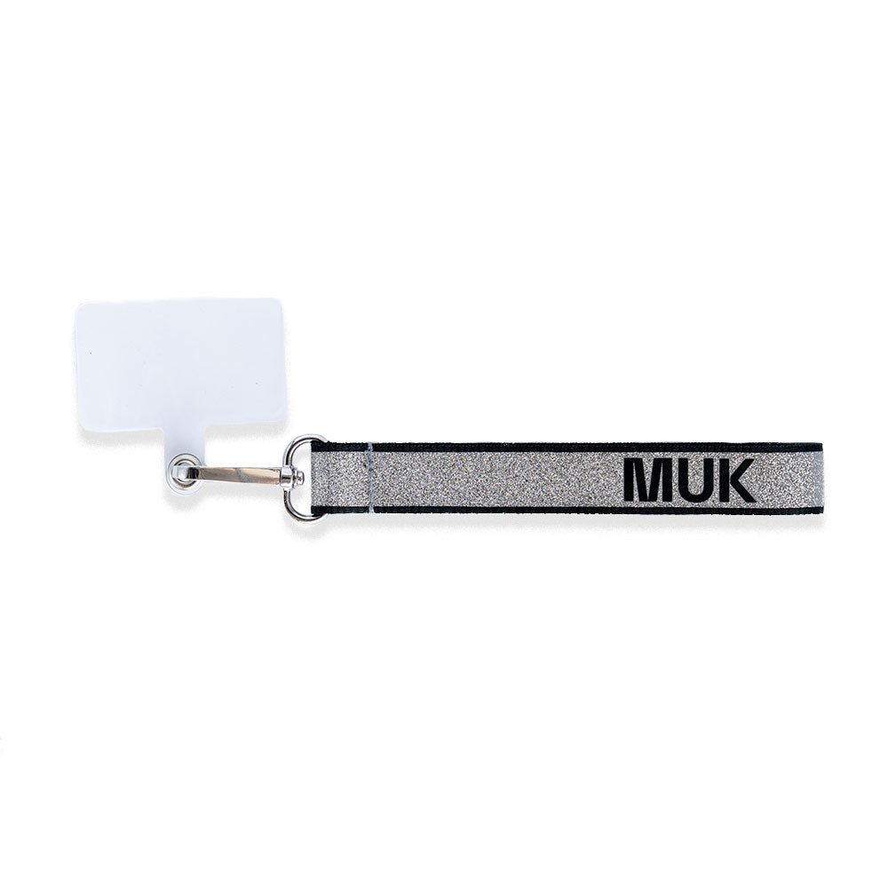 Cuerda universal de purpurina metalizada con el logo de Muk en negro. Dispone de un mosquetón para poder usar como phonestrap con el adaptador universal transparente (viene incluido), o bien, como llavero.
